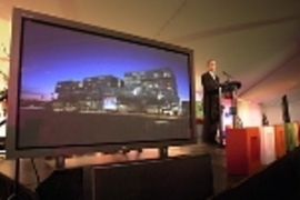 Simmons Hall is aglow on screen to President Charles Vest's right at the dedication of the new dorm last Friday.