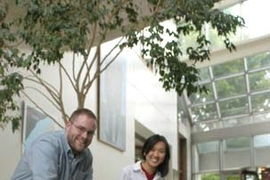 Postdoctoral associate Russ Tedrake and alumna Teresa Weirui Zang watch their robotic toddler navigate the medical building foyer.