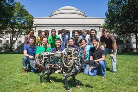 MIT Biomimetic Robotics Laboratory members pose with the MIT cheetah robot in Killian Court. (Top row, from left) Deborah Ajilo, Negin Abdolrahim Poorheravi,John Patrick Mayo,Justin Cheung, Sangbae Kim, Shinsuk Park, Kathryn L. Evans, and Matt Angle. (Bottom row, from left) Will Bosworth, Joao Luiz Almeida Souza Ramos, Sehyuk Yim, Albert Wang, Meng Yee Chuah, and Hae Won Park. 