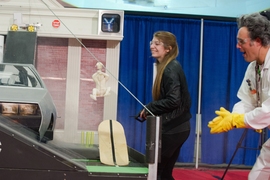 Winter watches as first-place finisher Ali Edwards, a sophomore in mechanical engineering, scores the game-winning points by getting the plastic figure of Dr. Brown to slide down a cable.