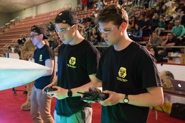 Sophomore Brandon McKenzie (center, with hat) and second driver Joshua Graves (right) compete in the 2017 MIT Mechanical Engineering 2.007 Student Design Final Robot Competition. McKenzie would go on to place third in the competition.