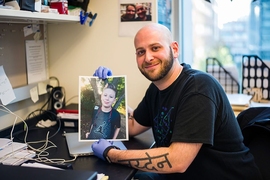 Ryan Kohn, a PhD candidate in the MIT Biology Department’s Jacks Lab, holds a photo of his son, Jayden.
