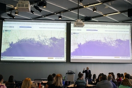 Professor John Sterman displays maps showing the consequences of sea-level rise on various coastal cities, as part of the “SimPlanet” event at MIT.