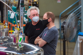 Two engineers talk in the test hall where the magnet will be demonstrated