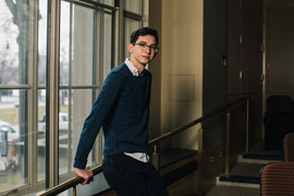 David Darrow leaning against a windowsill in a classroom