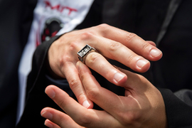 Closeup of a graduate’s hands, wearing the “brass rat” class ring