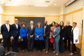 A group photo shows 11 people smiling in a conference room, including Jarrett and Reif in center.