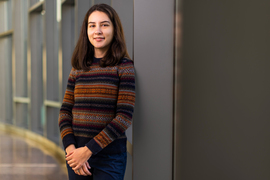 Valeria Robayo stands inside MIT Sloan and wears her Brass Beaver ring.