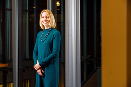 Stefanie Jegelka stands inside in a doorway with glass walls.