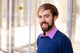 Matthew Kearney portrait with sunny glass walls and doors in background.