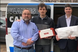 3 men stand outside in front of a van, and Lagazzi holds the Surgibox module. Teodorescu holds a mail package.