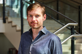 Portrait photo of Dean Eckles with staircase in background.