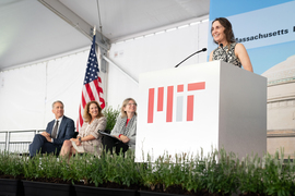 Bonnie Berger speaks at the podium as Ian Waits, Cynthia Barnhart, and Sally Kornbluth watch. The podium has an MIT log on it.