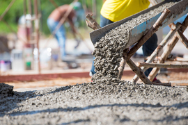 Wet concrete being poured at a construction site.