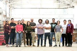 A group photo of 9 members of the Noya team outside on a deck, including Josh Santos, second from left.