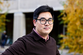 Portrait of David Hsu outside, with yellow foliage in background.