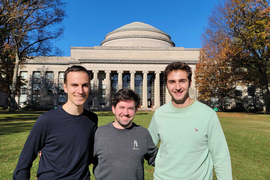 Three people stand in Killian Court with Great Dome in background.