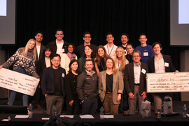 Group photo with two large checks.